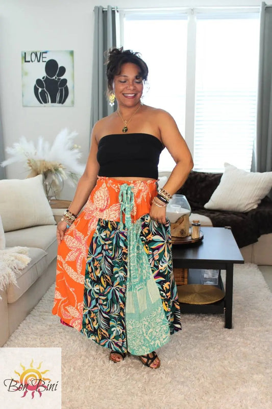 Model in sandals holding unique bohemian wrap skirt.