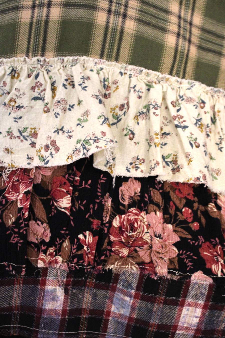 Close-up of plaid shirt showing the 3 tiered ruffled edge with multiple floral prints.