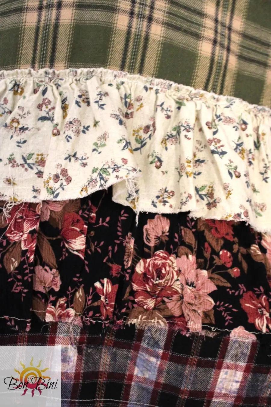 Close-up of plaid shirt showing the 3 tiered ruffled edge with multiple floral prints.