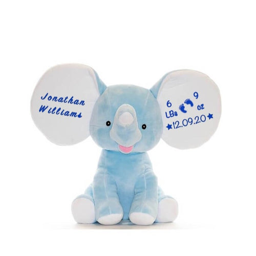 Light blue elephant sitting upright with large white ears, white feet bottoms, pink mouth, and small black eyes. Has blue text depending on variant selected on ears.