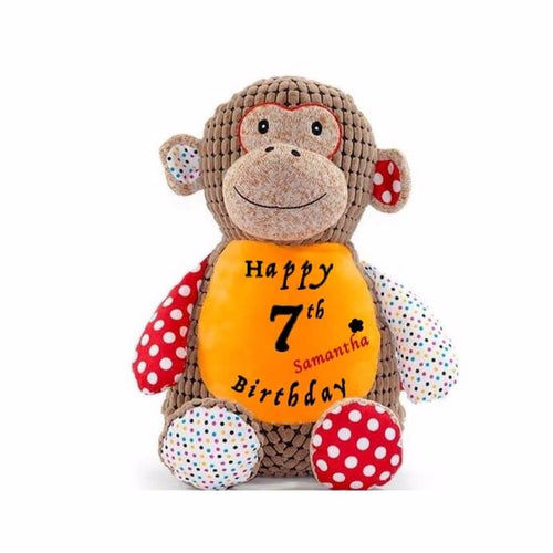 Brown patchwork monkey sitting upright with orange belly, small rainbow polka dots pattern, red with white polka dots pattern, 