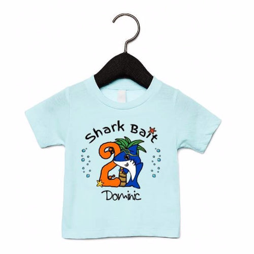 Ice blue t-shirt with blue cute shark, orange birthday number, and a child's name underneath the design