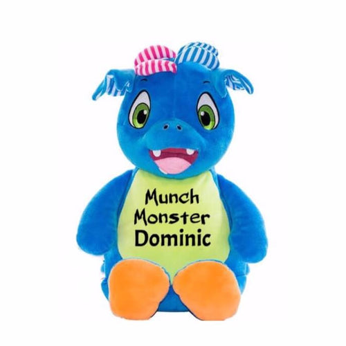 Blue stuffed patchwork dragon sitting upright with light green belly, orange feet pads, green eyes, and 