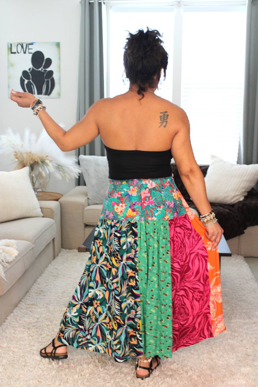 Model in a colorful patchwork wrap skirt standing showing the back unique print.