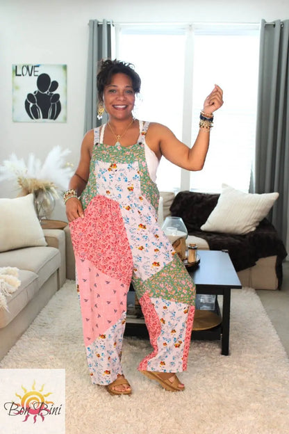 Model in rosa verde colorful floral patchwork overall with pink and green print.