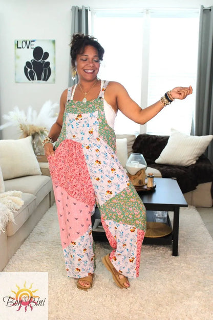 Model wearing a colorful patchwork floral overall.