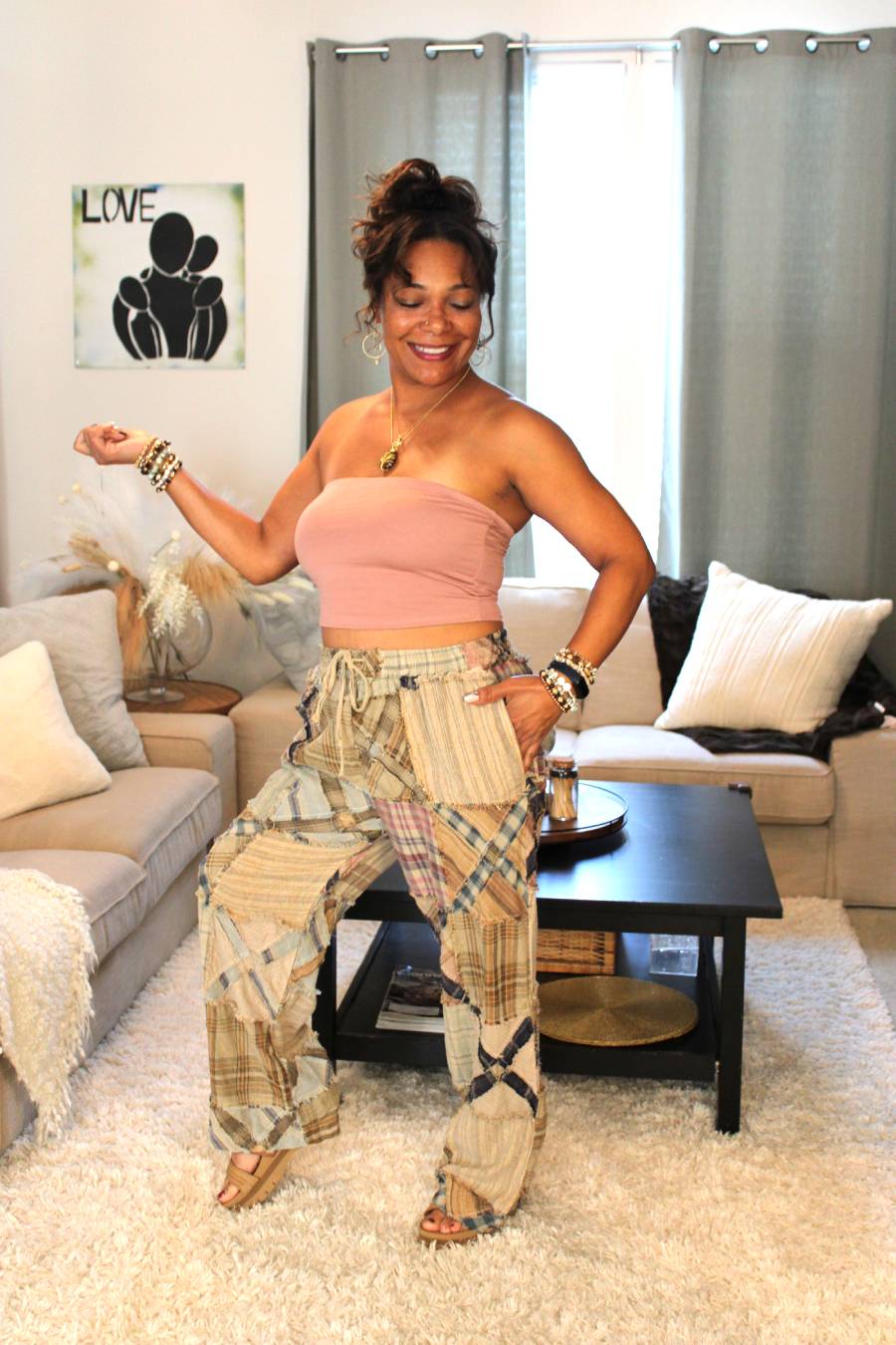 Model posing in a pink bamboo tube top and plaid pants featuring an x pattern similar to railroad crossings.