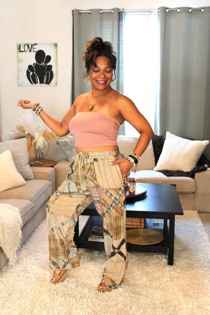 Model posing in a pink bamboo tube top and plaid pants featuring an x pattern similar to railroad crossings.