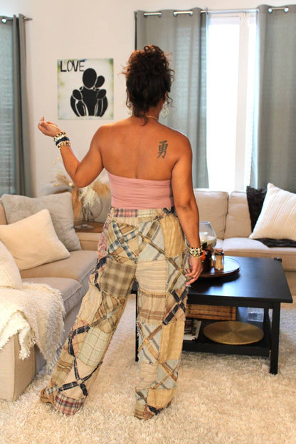 Model showcasing the backside of a pink bamboo tube top and plaid pants. Plaid pants feature an x pattern similar to railroad crossings.