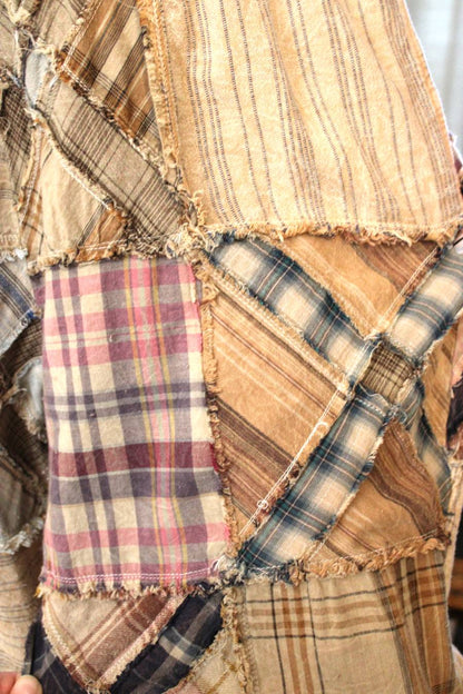 Close-up of a patchwork fabric with various patterns, colors, and an X design remisniscent of a rail road crossing.