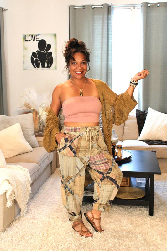 Model posing and wearing a pink tube top, bronze Aurora Boho Knit Cardigan, and plaid pants.