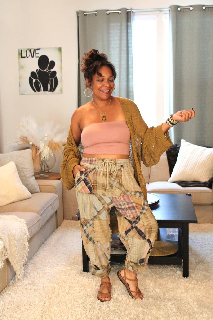 Model standing and wearing a pink tube top, bronze Aurora Boho Knit Cardigan, and plaid pants.