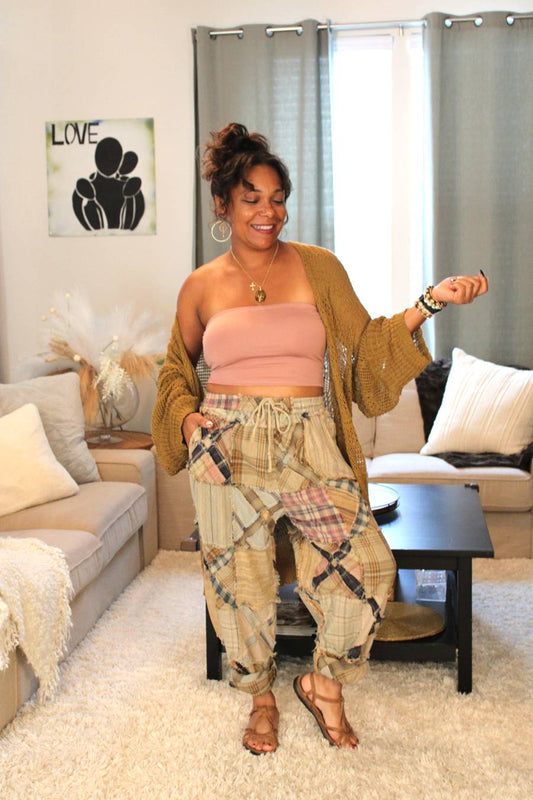 Model standing and wearing a pink tube top, bronze Aurora Boho Knit Cardigan, and plaid pants.