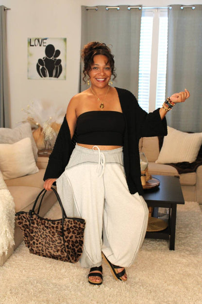 Model with a leopard print bag, black crop top, & gray thermal jogger pants.