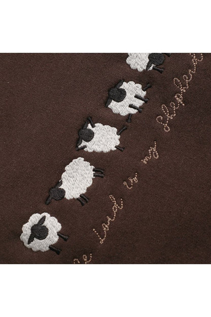 Close-up of the embroidered sheep doing cute yoga poses.