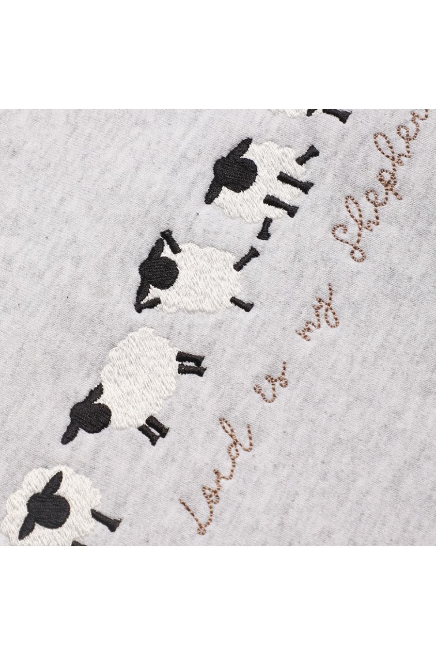 Close-up of the embroidered sheep doing cute yoga poses.
