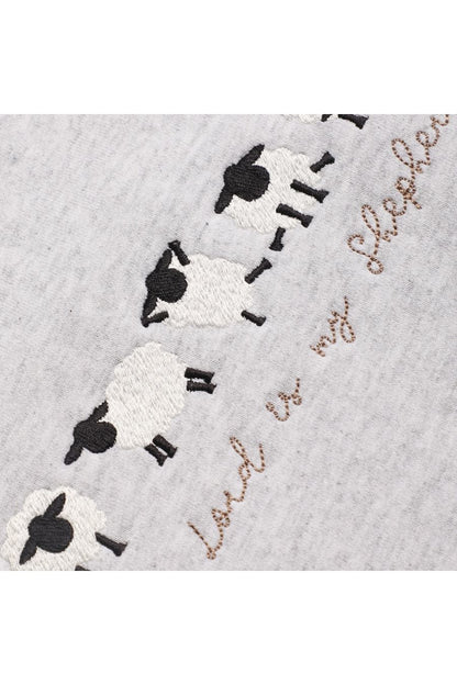 Close-up of the embroidered sheep doing cute yoga poses.