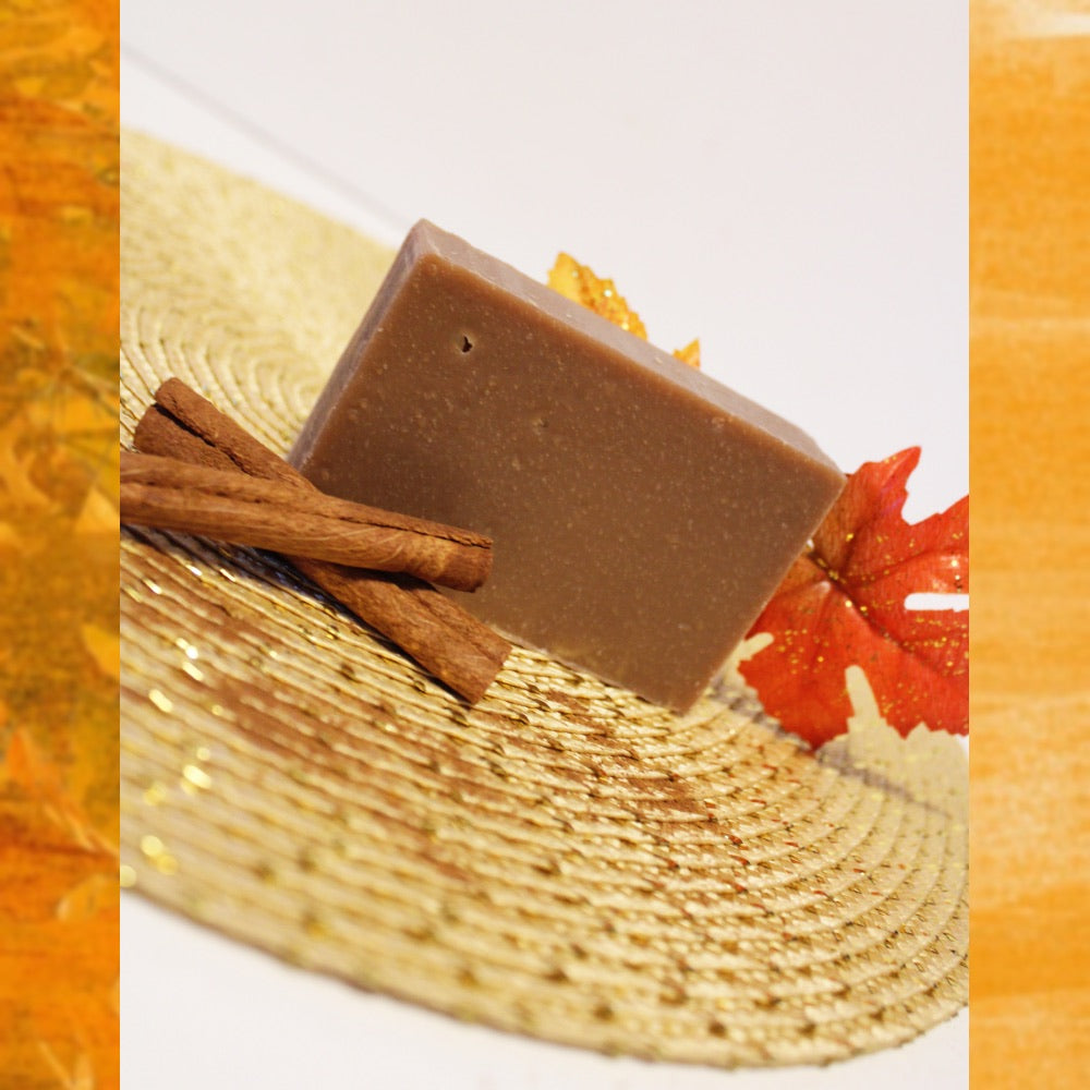 Brown colored soap bar next to cinnamon sticks.